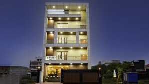 A multi-story hotel with a modern design, featuring a prominent entrance with glass doors and a signboard. - Treebo Grand Vista - 63A (Noida)