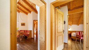 A wooden interior with a dining area, a bench, and a bed. - Apartment 'Obermoarhof Ifinger' with Mountain View, Shared Garden and Wi-Fi (Lagundo)