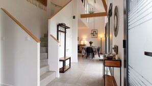 A staircase leading to a dining area with a table and chairs, a bench, and a wall-mounted coat rack.