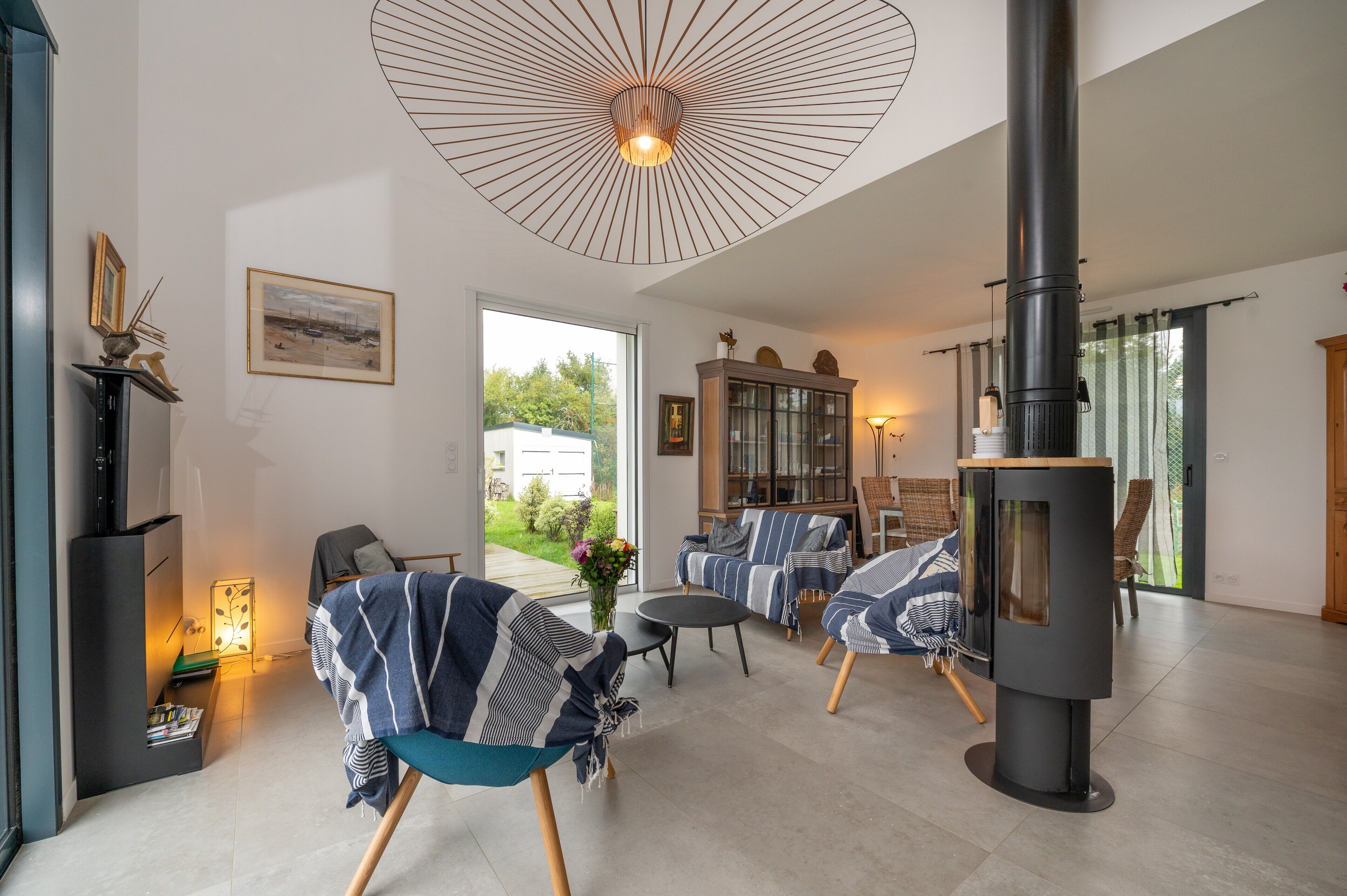 Una sala moderna con chimenea, asientos cómodos y un ventanal grande.