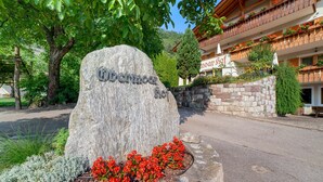 A stone sign with 'Obermoar' inscribed, a building with balconies, and a tree in the foreground. - Apartment 'Obermoarhof Mutspitze' with Mountain View, Shared Garden and Wi-Fi (Lagundo)