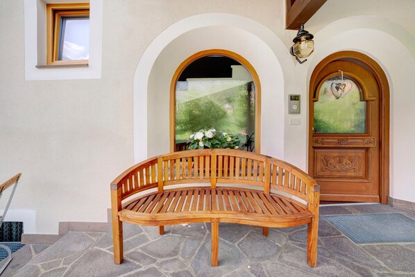 A wooden bench in front of a building with two arched doorways and a window. - Apartment 'Obermoarhof Mutspitze' with Mountain View, Shared Garden and Wi-Fi (Lagundo)