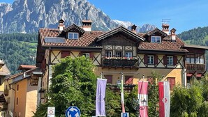 Ein traditionelles Chalet mit Balkon vor einer Bergkulisse.