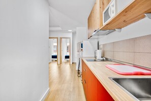 A modern kitchen with wooden cabinets, a stainless steel sink, and a patterned backsplash.