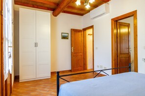 A bedroom with a bed, wardrobe, and two doors.