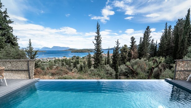 Una piscina con vistas al mar y a las montañas.