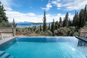 Una piscina con vistas al mar y a las montañas.