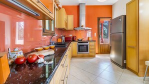 Una cocina con una isla central, horno empotrado y refrigerador.
