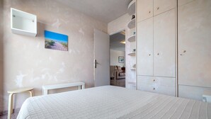 A bedroom with a bed, a small table, a wardrobe, and a picture on the wall. - 'Mirador Altafulla' 5th Floor with Two Terraces and Elevator (altafulla)