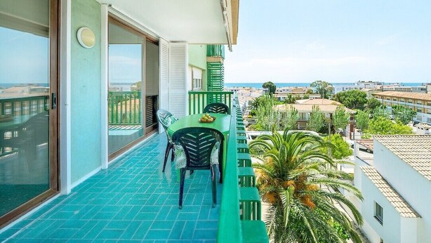 A balcony with a table and chairs, a view of the sea, and buildings in the background. - 'Mirador Altafulla' 5th Floor with Two Terraces and Elevator (altafulla)