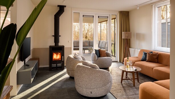 A modern living room with a fireplace, comfortable seating, and a television.