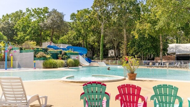 A swimming pool with a water slide, surrounded by trees and lounge chairs. - Mobile Home for 6 Guests with Shared Pool and Private Terrace (Saint-Brevin-les-Pins)