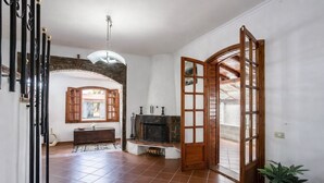 A spacious living area with a fireplace, a bench, and a large window. - Villa 'Casa Al Mare' with Private Terrace, Wi-Fi and Air Conditioning (Siracusa)