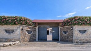 A stone building with a red roof, a gated entrance, and flower boxes on the walls. - Villa 'Casa Al Mare' with Private Terrace, Wi-Fi and Air Conditioning (Siracusa)