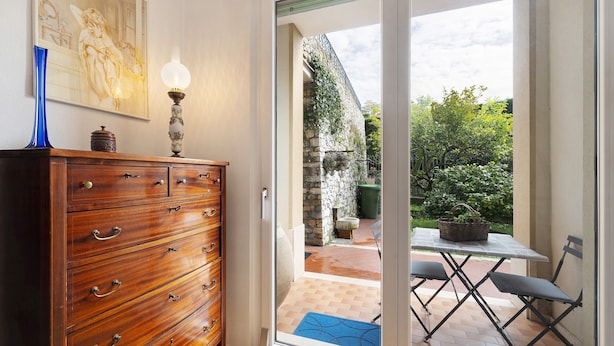 A wooden dresser with drawers, a blue vase, and a framed picture on the wall. - Apartment 'Il Giardino Di Giò' with Mountain View, Private Terrace and Wi-Fi (Finale Ligure)