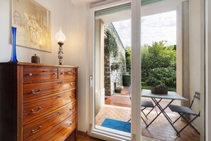 A wooden dresser with drawers, a blue vase, and a framed picture on the wall. - Apartment 'Il Giardino Di Giò' with Mountain View, Private Terrace and Wi-Fi (Finale Ligure)