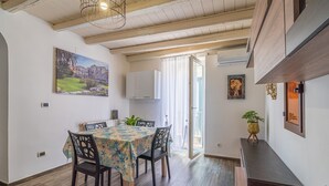 A dining area with a table, chairs, and a painting on the wall. - Holiday Apartment 'Cheyenne's House' with Terrace, Balcony & Wi-Fi (Siracusa)