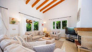 A living room with a sofa, armchairs, a TV, and a fireplace. - Villa 'Victoria' with Private Pool, Wi-Fi and Air Conditioning (Crestatx)