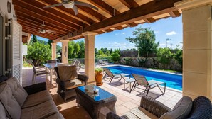 An outdoor patio with a pool, wicker furniture, ceiling fans, and a view of the surrounding landscape. - Villa 'Victoria' with Private Pool, Wi-Fi and Air Conditioning (Crestatx)