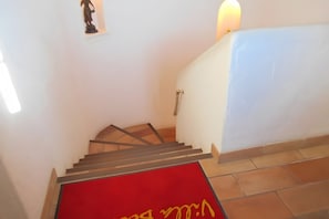 Un escalier recouvert d’une moquette rouge menant à un palier.