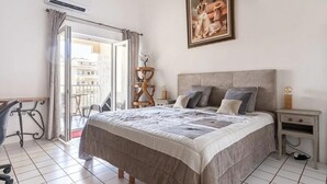 Un dormitorio con cama, mesita de noche y un cuadro en la pared.