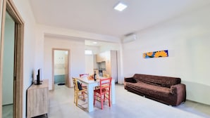 A modern apartment with a dining area, kitchen, and living space. - Apartment 'Appartamento Della Luna 2' with Sea View, Balcony and Wi-Fi (Alcamo)