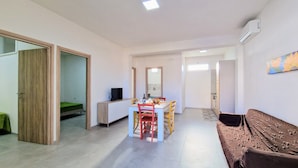 A modern apartment with a dining area, a living room, and a kitchenette. - Apartment 'Appartamento Della Luna 2' with Sea View, Balcony and Wi-Fi (Alcamo)