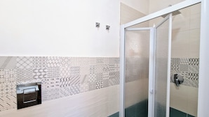 A shower area with patterned tiles, a glass door, and a towel dispenser. - Apartment 'Appartamento Della Luna 2' with Sea View, Balcony and Wi-Fi (Alcamo)
