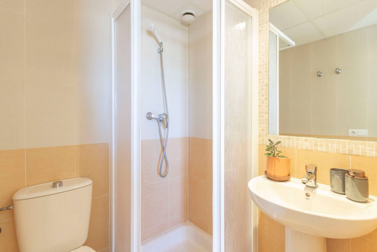 A bathroom with a shower, toilet, and sink.
