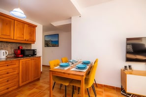 Una cocina compacta con armarios de madera, un microondas y una cafetera.