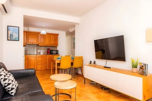 A compact living space with a dining area, kitchenette, and a flat-screen TV. - Can Jaume B Apartment, Central Location in Artà (Arta)