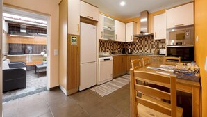 Eine moderne Küche mit Essbereich, einem Kühlschrank, einer Mikrowelle und einem Geschirrspüler.