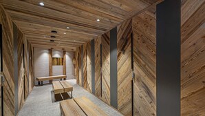 A hallway with wooden panel walls and a central bench. - New apartment in Méribel with sauna and parking (Méribel)