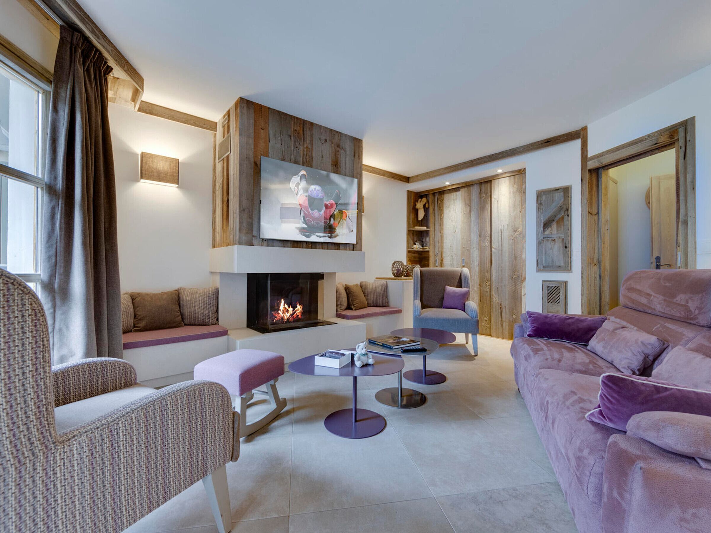 Een moderne woonkamer met een open haard, comfortabele zitmogelijkheden en een televisie.