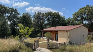A small house with a gravel driveway and a wooden fence.