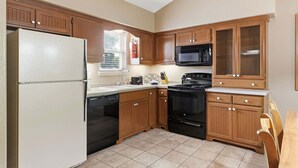 A kitchen with wooden cabinets, a refrigerator, a microwave, a dishwasher, and a stove. - King Bed Condo at StoneBridge Village Resort (Reeds Spring)