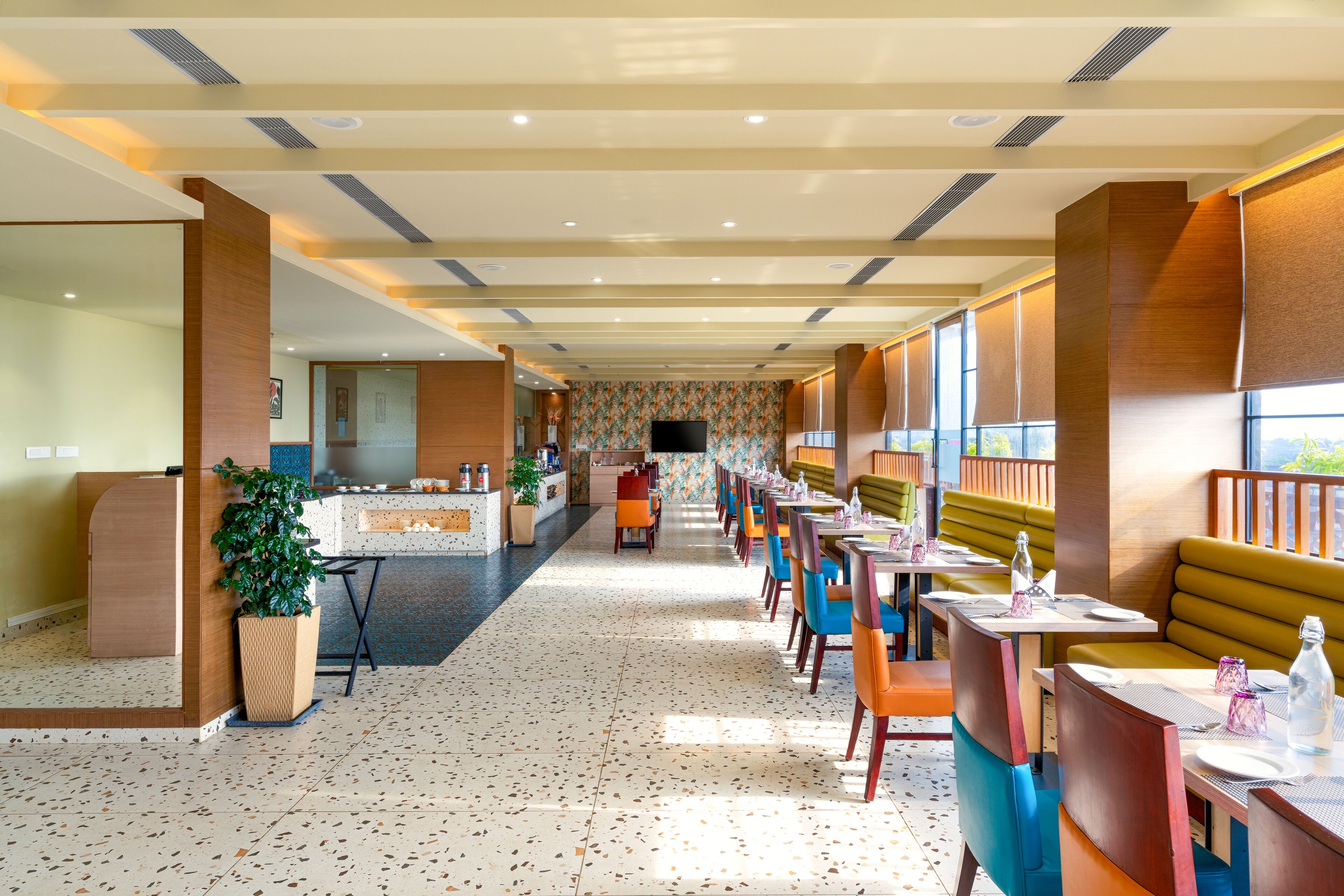 Eine Hotelhalle mit einer langen Rezeption, einer Sitzecke und einer Wand mit Muster.
