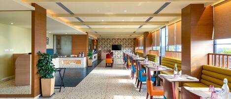 Eine Hotelhalle mit einer langen Rezeption, einer Sitzecke und einer Wand mit Muster.