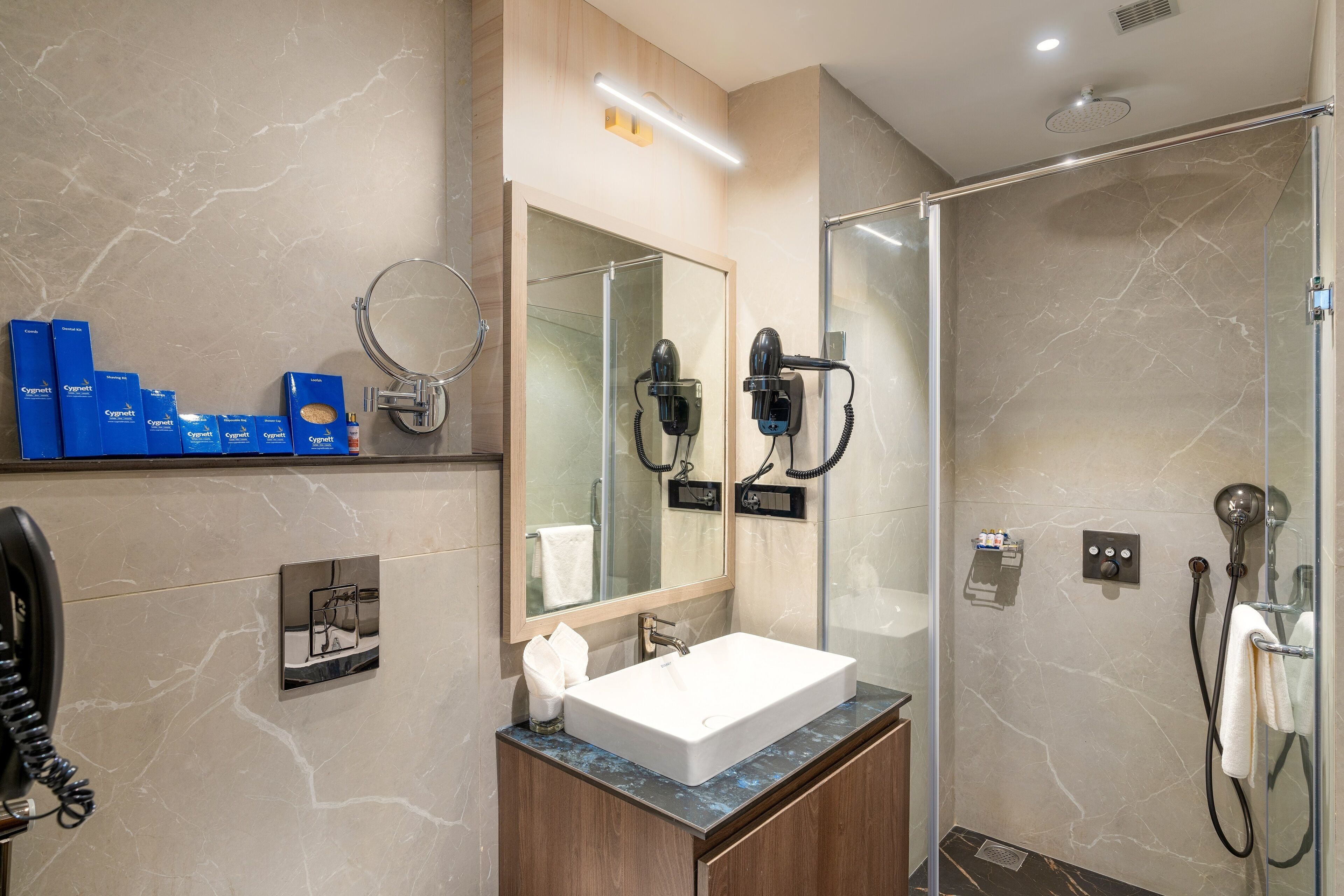 A modern bathroom with a large mirror, a sink, and a shower area.