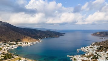 A coastal town with white buildings, a marina, and clear blue waters.