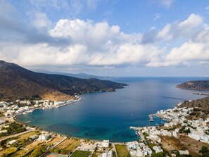 A coastal town with white buildings, a marina, and clear blue waters. - Soil Amorgos (Amorgos)