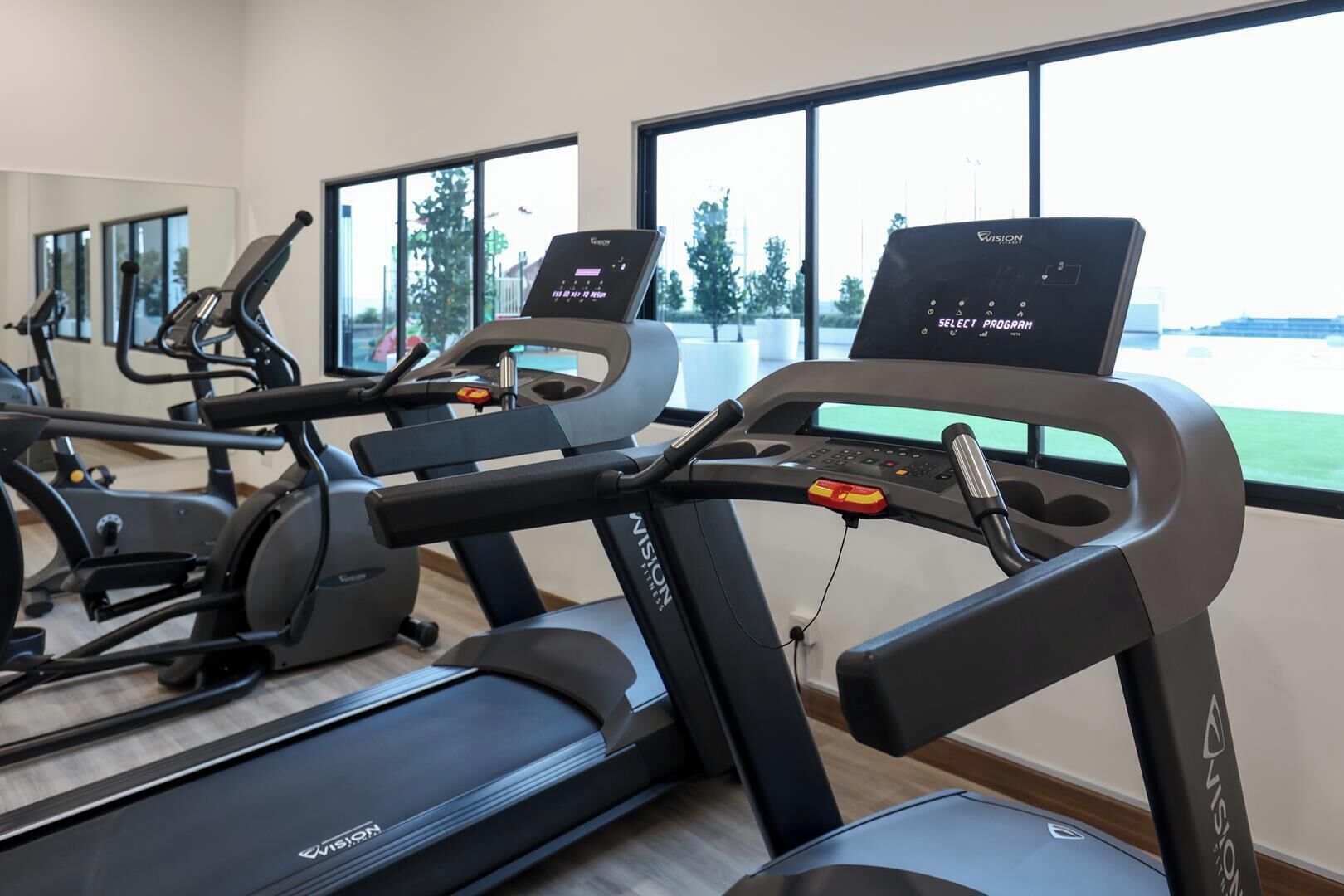 A gym with treadmills, stationary bikes, and a rowing machine.