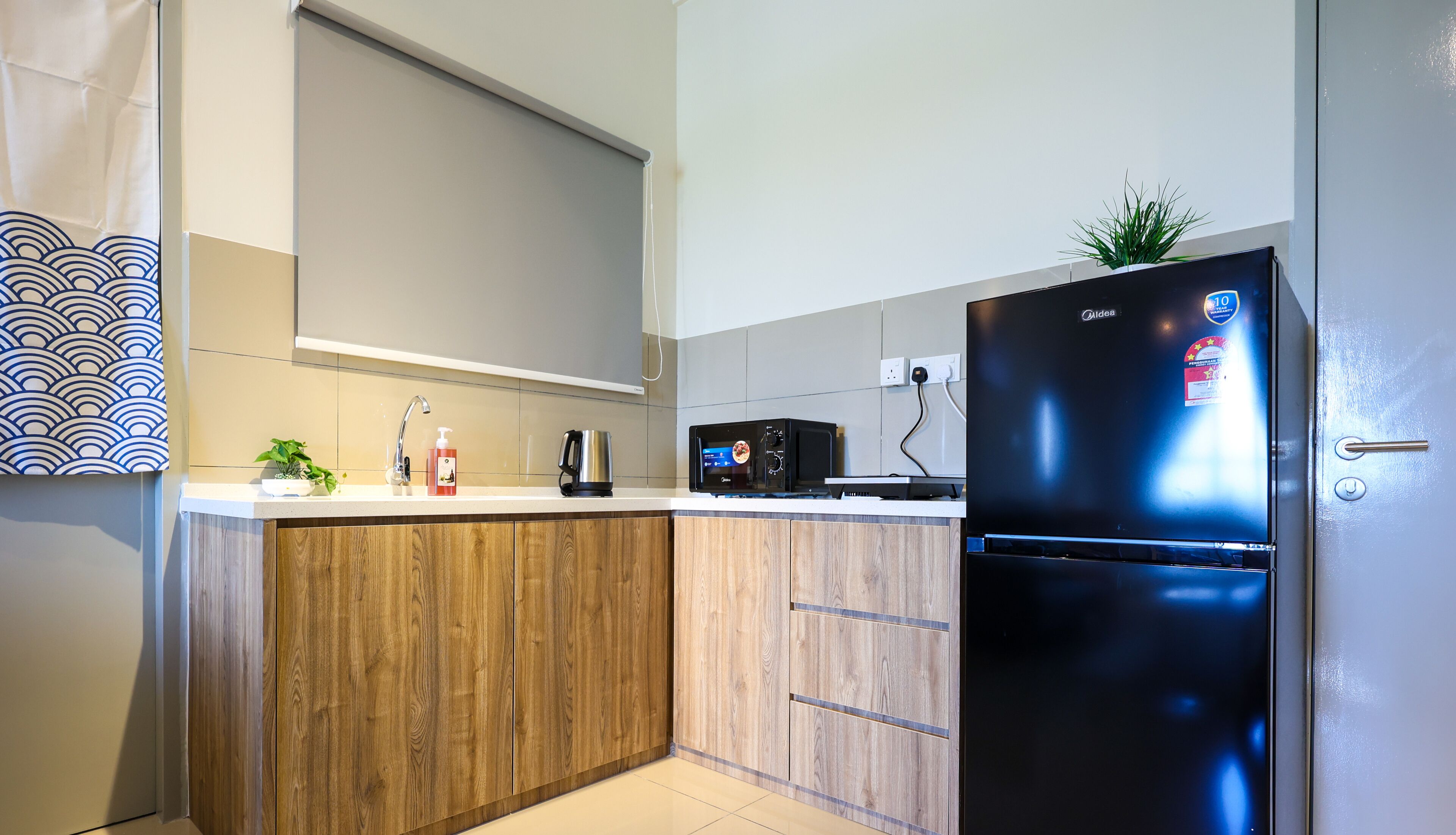 A modern kitchen with wooden cabinets, a black refrigerator, a microwave, and a sink.