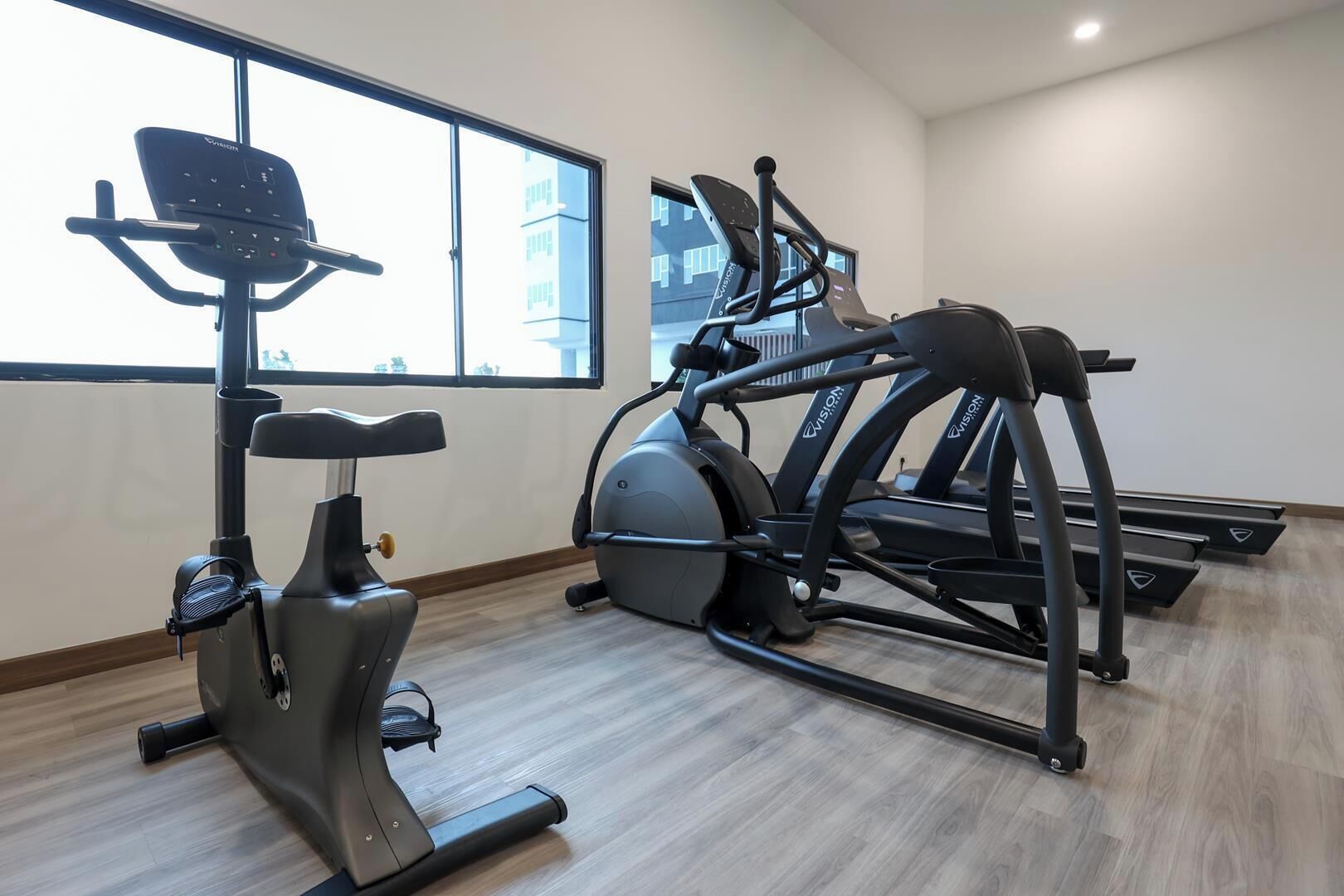 A gym with an elliptical trainer, a stationary bike, and a treadmill.