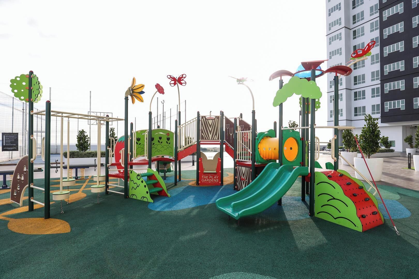 A playground with slides, climbing structures, and a fenced play area.