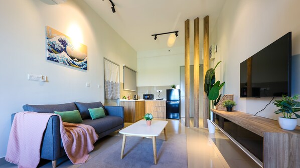 A modern living room with a sofa, coffee table, and a flat-screen TV. - Amber Cove Residence By I Housing  (Malacca City)