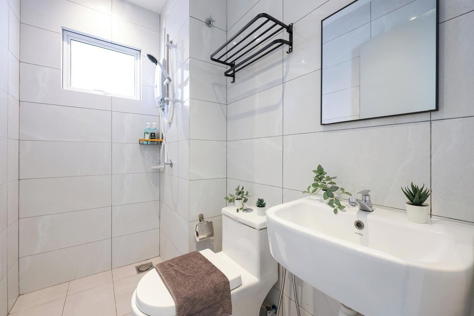 A modern bathroom with a shower, toilet, and sink.