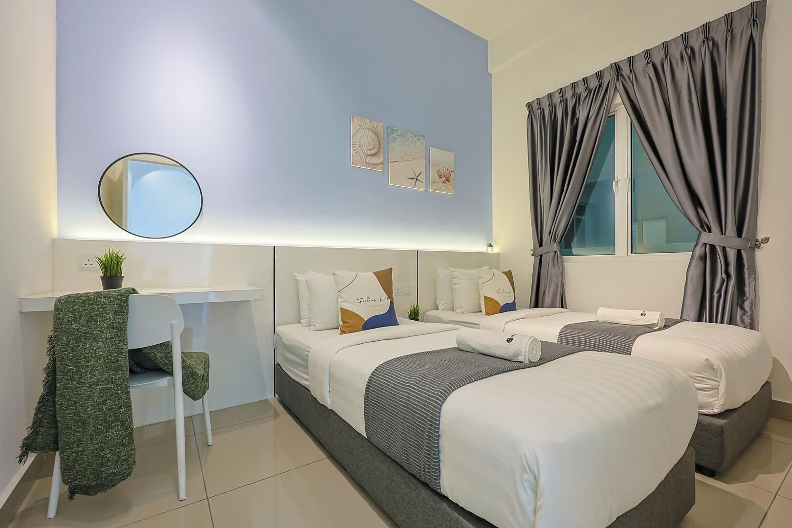A modern hotel room with two beds, a desk, a chair, and a large window with curtains.