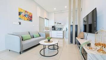 A modern living room with a sofa, a coffee table, and a TV.
