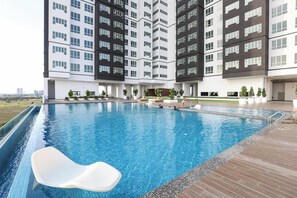A swimming pool with a clear view of a modern building in the background.